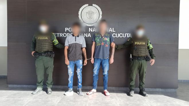 Personas capturadas-policías custodiando