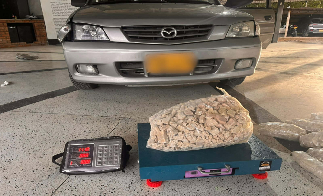 Un auto color gris y en frente báscula con estupefacientes