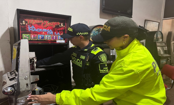 Personal de la direccion de Policia Fiscal y aduanera incautando la maquina de juegos de azar