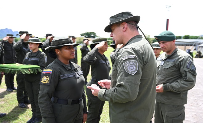 mujer policía recibiendo distintivo