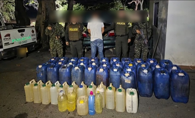 Fotografía de los 272 galones incautados junto al capturado 