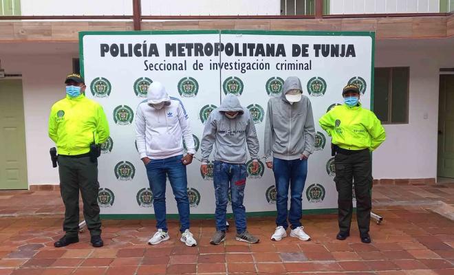 Personas capturadas y policías custodiando