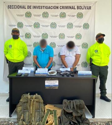 Personas capturadas-policías custodiando