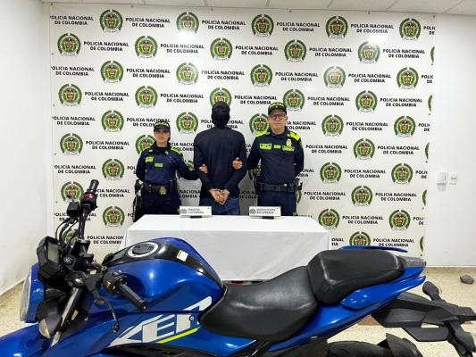 Hombre capturado en medio de dos policias, en frete motocicleta recuperada