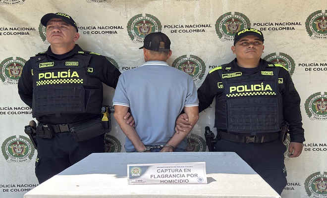 Dos policías con un capturado en el backing institucional 