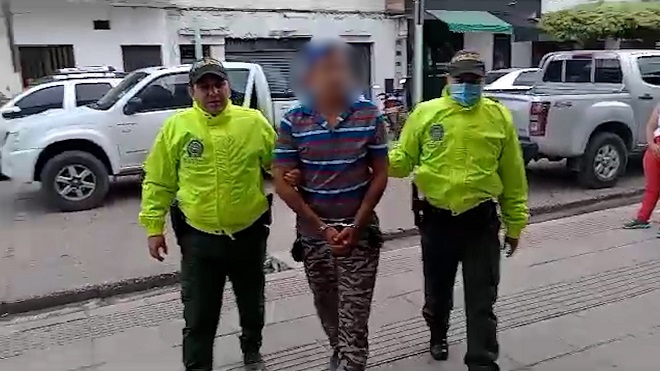 Personas capturadas-policías custodiando