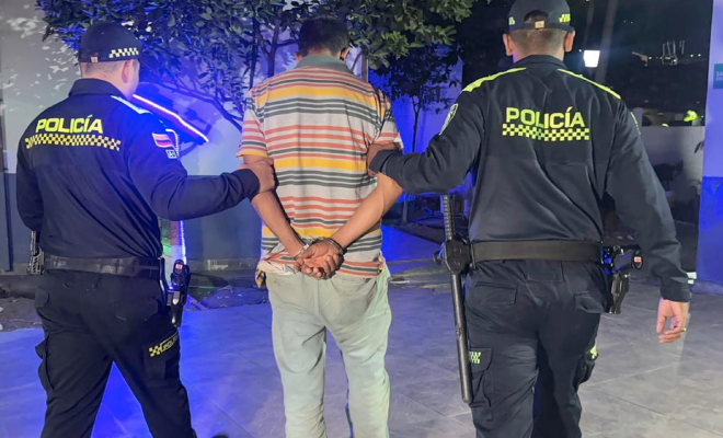 Hombre capturado con las manos esposadas en medio de dos polic&iacute;as