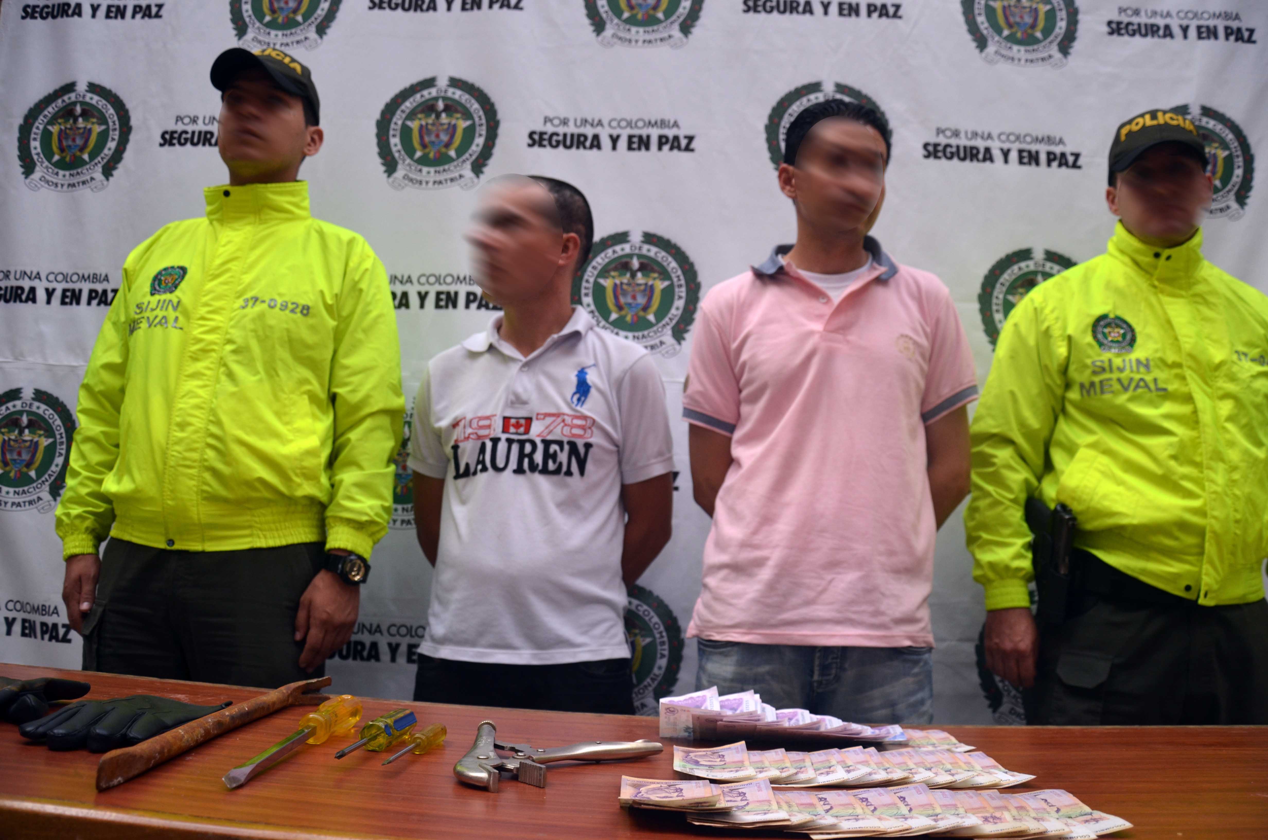 Investigadores de la Sijin en Medellín custodian a dos hombres capturados por el delito de hurto de residencias