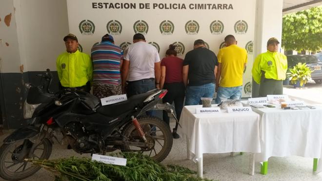 Personas capturadas-policías custodiando
