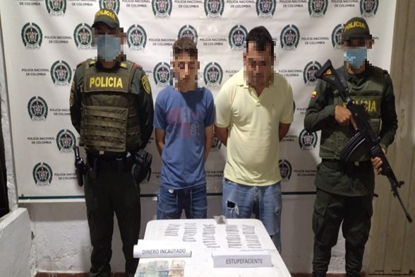 Personas capturadas-policías custodiando