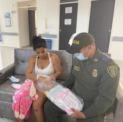 Policía entregando regalo a mamá del bebe recién nacido