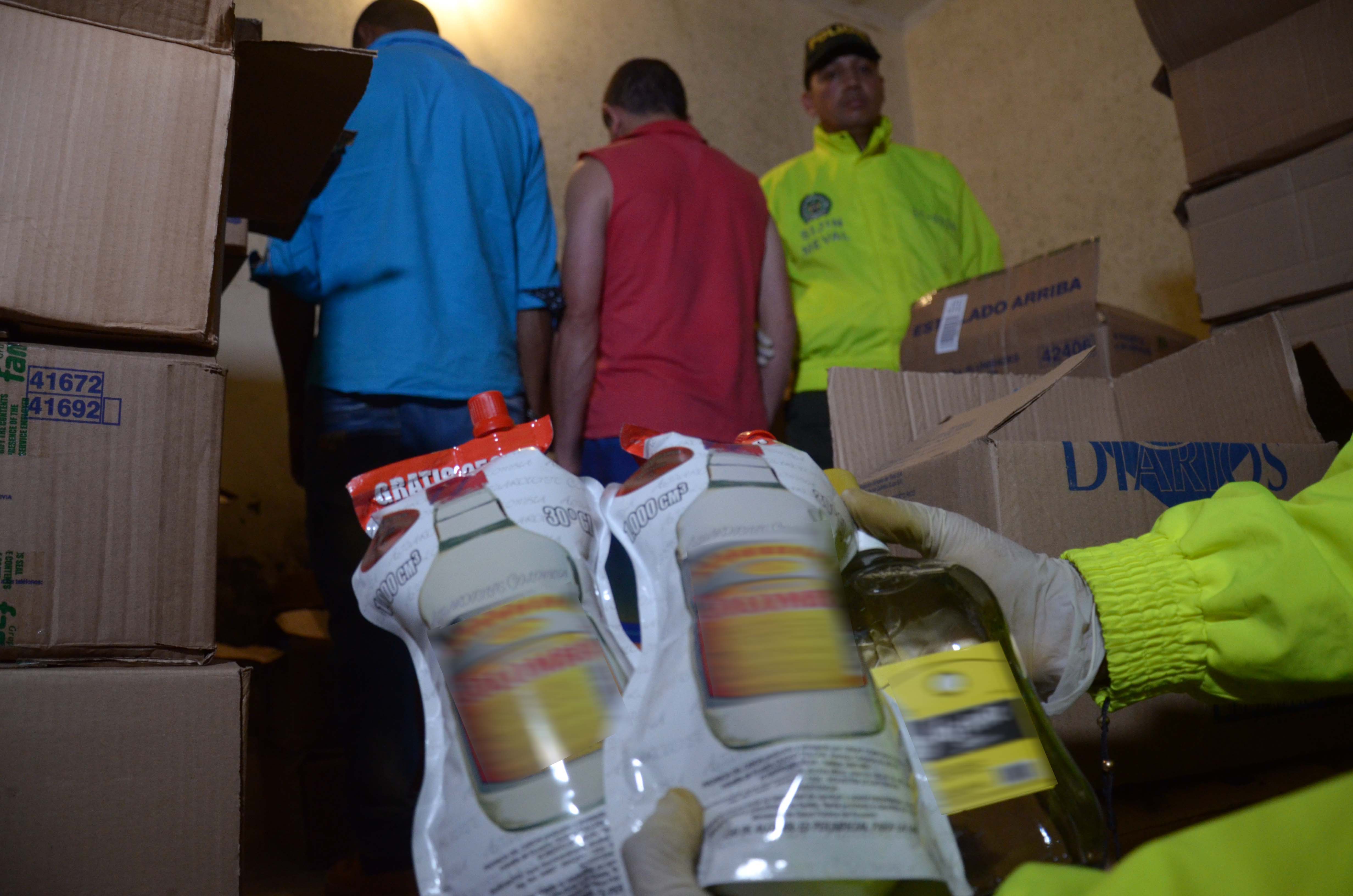 Policías custodían capturados con licor adulterado