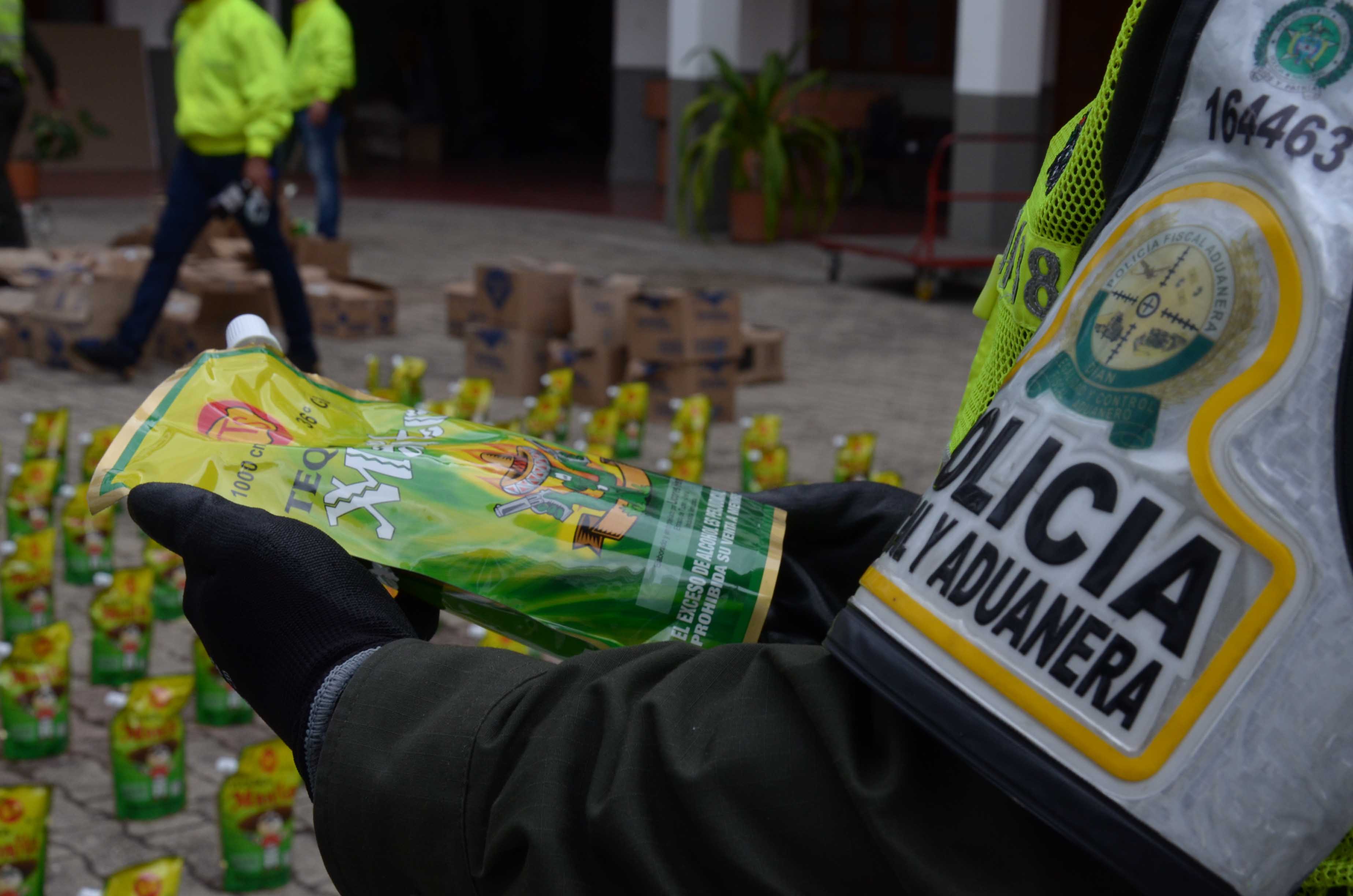 Policía observa una bolsa doy pack con licor adulterado