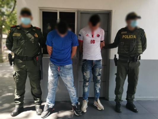 2 personas capturadas-policías custodiando