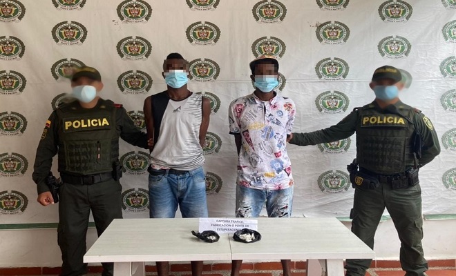 Dos capturados-policías custodiando-alucinógenos incautados