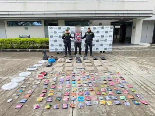 Dos policías al lado de un hombre con estupefacientes