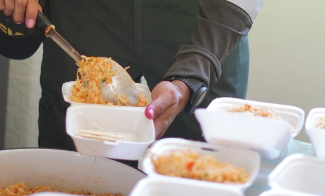 Empacando las comidas en platos desechables que se van a repartir