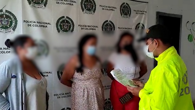 3 personas capturadas-policías custodiando
