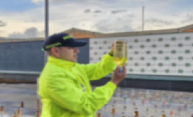 Uniformado de la sijin revisa el contenido de las botellas de licor adulterado en procedimiento policial