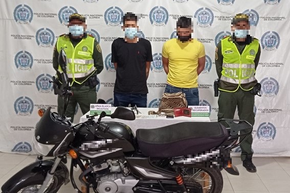 2 personas capturadas-policías custodiando