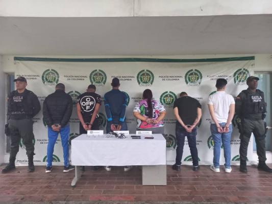 Personas capturadas-policías custodiando 