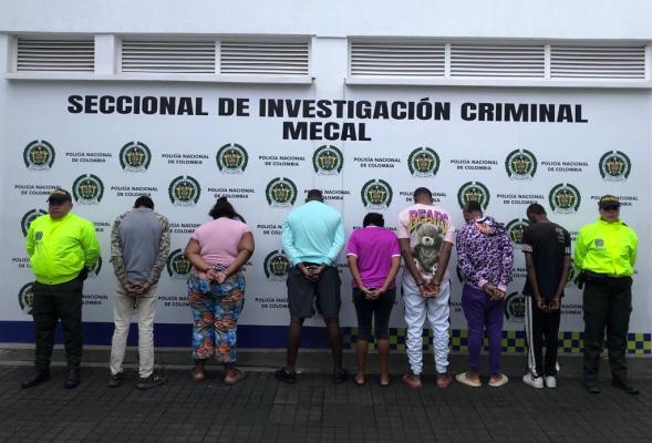 Personas capturadas-policías custodiando