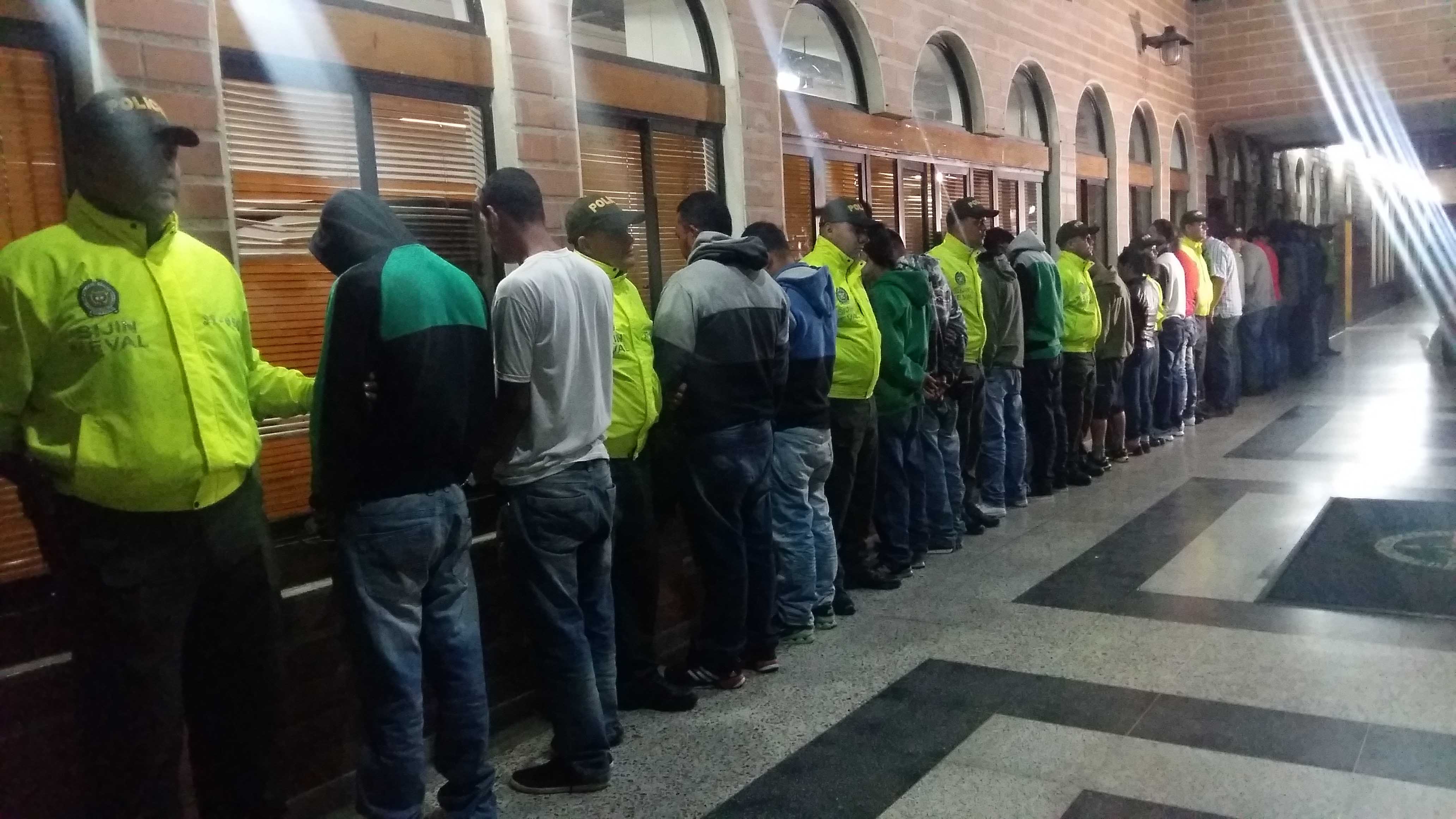 Personas capturadas en Medellín de espaldas y custodiadas por Policías