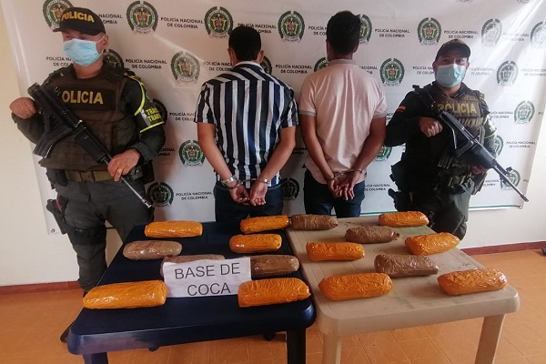 dos personas capturadas-policías custodiando-alucinógeno incautado 