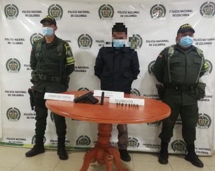 una persona capturada-policías custodiando-arma de fuego incautada