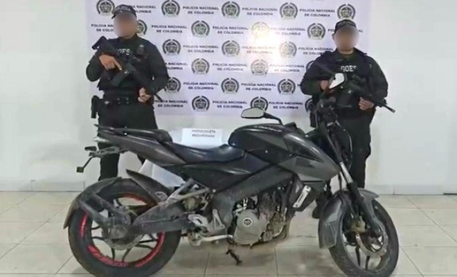 Dos policías frente a una moto recuperada