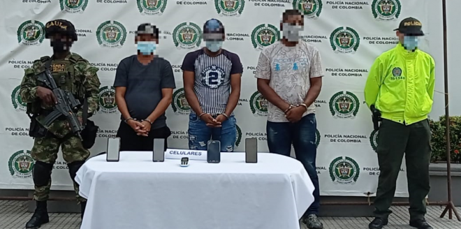 Tres personas capturadas-policías custodiando-celulares incautados
