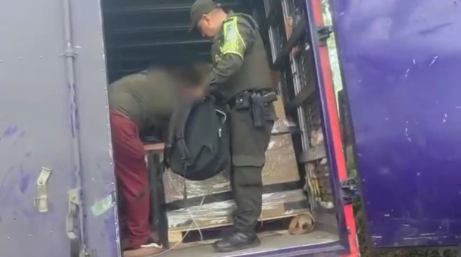 Un polic&iacute;a al lado de un hombre en un cami&oacute;n 