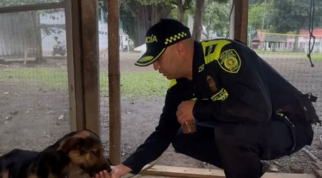 un policía al lado de un perro